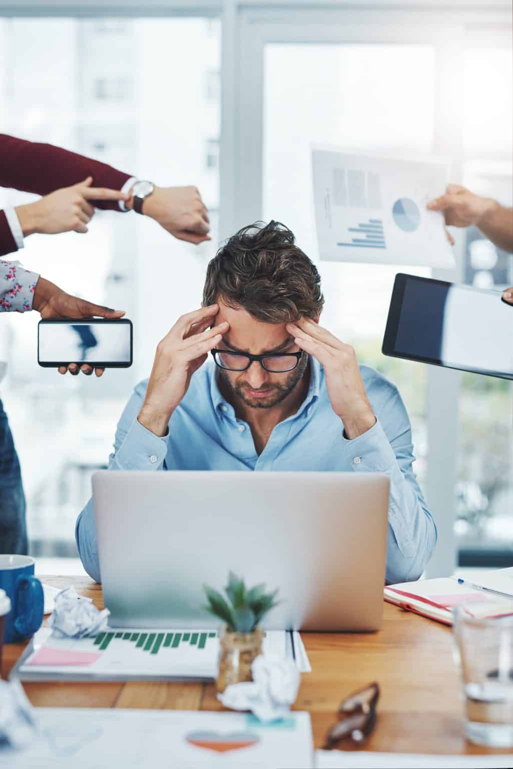 Overwhelmed business owner at his desk with everyone demanding answers at once